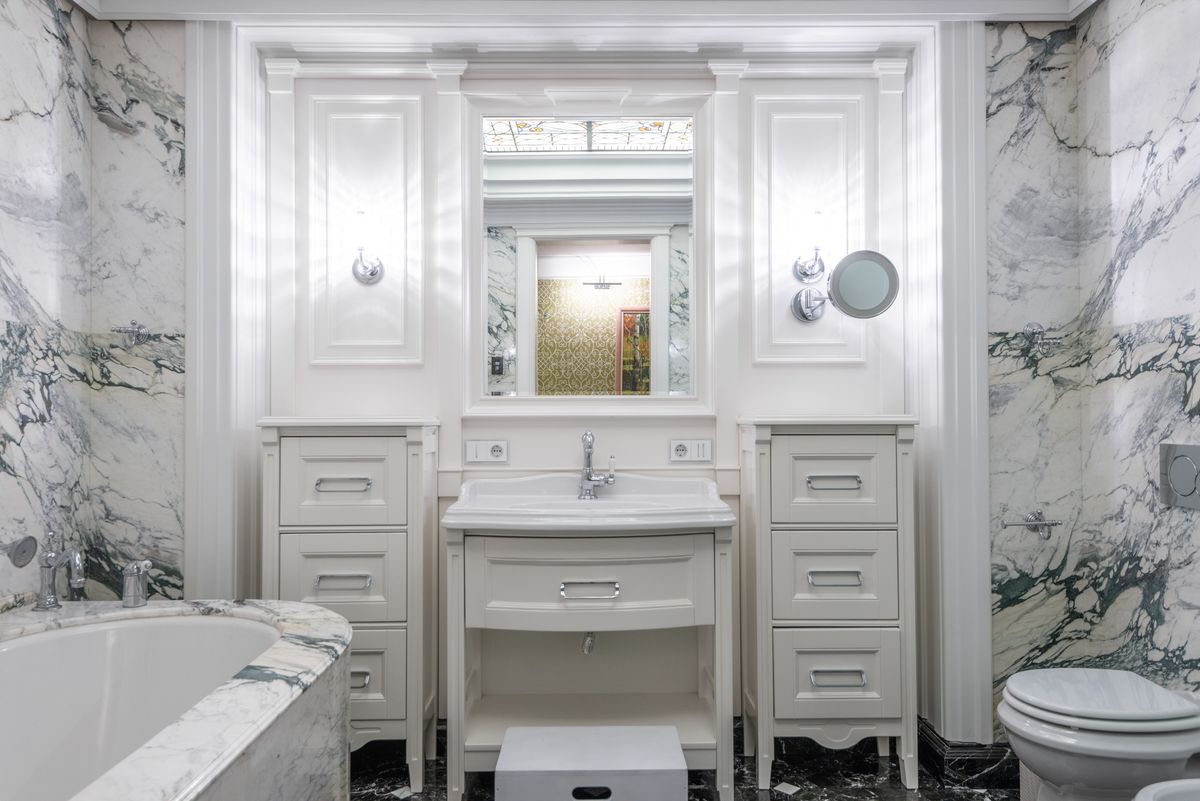 Classical white-and-green marble bathroom with book-matched stone walls